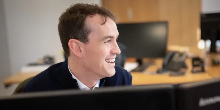 John Lamb Hill Oldridge broker Jacob Fay looks to the right from behind a monitor screen in his office.