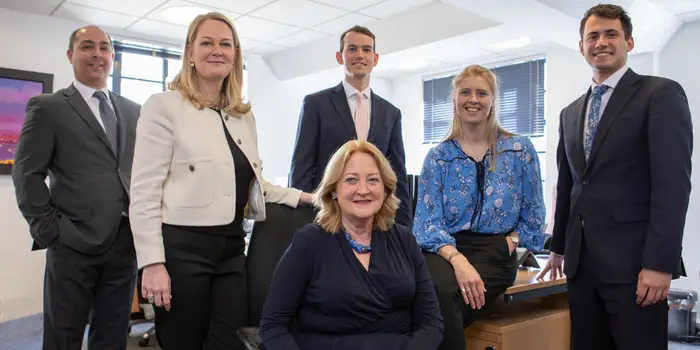 A group of businesspeople stand around an office space